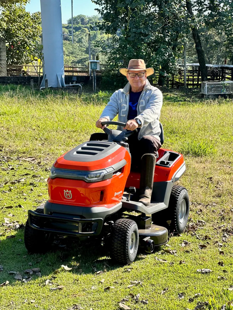 Cliente no trator cortador Husqvarna, no sítio