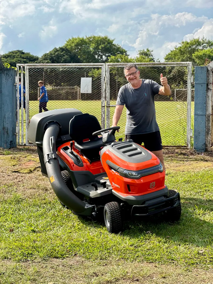 Cliente ao lado do seu novo trator cortador Husqvarna