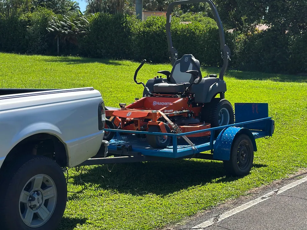 Giro zero Husqvarna carregado numa carreta atrás da caminhonete da Vardão para transporte até a oficina