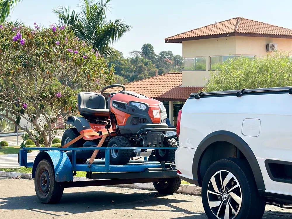 Trator cortador Husqvarna sobre a carreta da Vardão, entregue em um condomínio na região de Limeira
